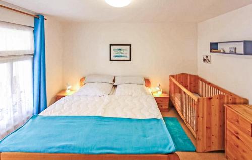 a bedroom with a large bed and a crib at Amazing Home In Dierhagen ostseebad With Wifi in Neuhaus