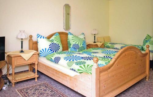 - une chambre dotée d'un lit en bois avec des oreillers bleus et verts dans l'établissement Lovely Apartment In Friedrichroda With Kitchen, à Friedrichroda