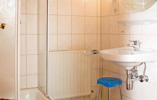 La salle de bains blanche est pourvue d'un lavabo et d'un tabouret bleu. dans l'établissement Lovely Apartment In Friedrichroda With Kitchen, à Friedrichroda