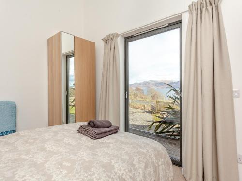 a bedroom with a bed and a large window at Airor in Kilmore