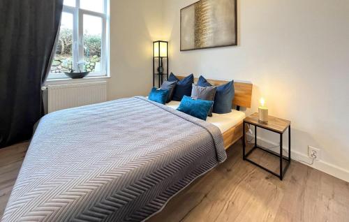 1 dormitorio con 1 cama grande con almohadas azules en Amazing Apartment In Blankenhagen With Wifi en Blankenhagen