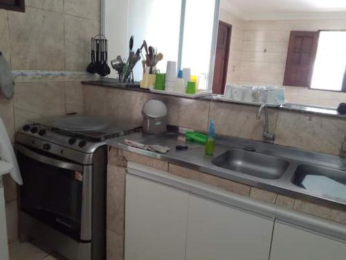 a kitchen with a sink and a stove at Sonho dos golfinhos in Recife