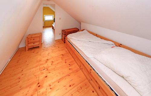 1 dormitorio con 1 cama y suelo de madera en Amazing Home In Zettemin Ot Rtzenfeld With Kitchen, en Varchentin