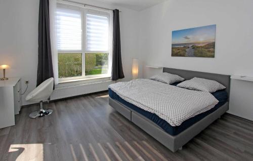 een slaapkamer met een bed en een groot raam bij Amazing Apartment In Neubrandenburg With Wifi in Neubrandenburg