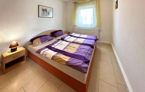 a small bedroom with a bed with purple sheets at 1 Bedroom Stunning Home In Klink in Klink