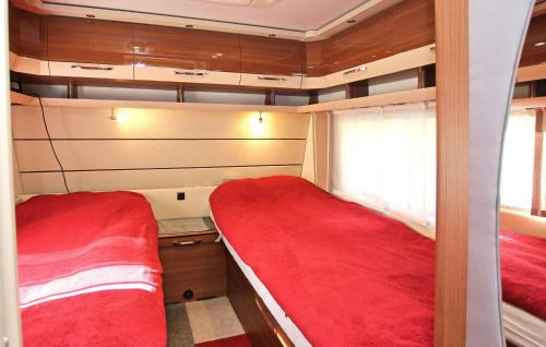 2 camas en una habitación pequeña con sábanas rojas en Stunning stacaravan In Rheinsberg Ot Kagar With Kitchen en Kagar