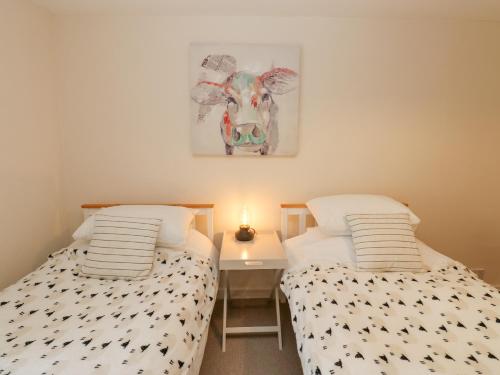 2 camas en una habitación con una foto de una vaca en Parkers House, en Alston