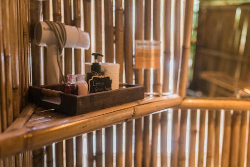 Bamboo Bay Island Resort في سورات ثاني: رف خشبي مع مجفف شعر ومصباح