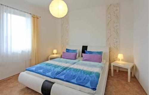 a bedroom with a large bed with blue and purple pillows at Beautiful Apartment In Neppermin-usedom With Wifi in Neppermin