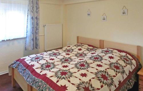 ein Bett mit einer Decke in einem Schlafzimmer in der Unterkunft Awesome Apartment In Zinnowitz seebad With Kitchen in Zinnowitz