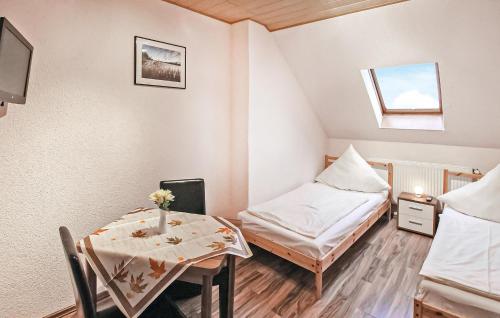 Cette petite chambre comprend une table, un lit et une fenêtre. dans l'établissement Awesome Apartment In Rheinsberg Ot Kleinzer With Wifi, à Kleinzerlang