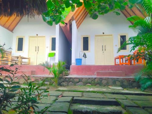 ein Haus mit einem steinernen Gehweg davor in der Unterkunft Putri Nyale Bungalow in Kuta Lombok