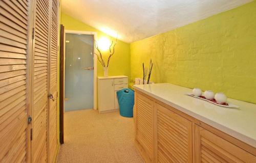 a bathroom with yellow walls and a counter with cups at Beautiful Home In Woldegk With Kitchen in Woldegk