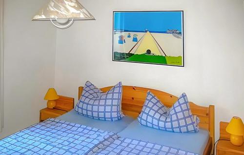 een slaapkamer met een bed met blauwe en witte kussens bij Beautiful Home In Benz-usedom With Kitchen in Benz