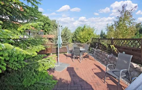 un patio avec des chaises, une table et un parasol dans l'établissement Ferienwohnung Karlshagen, à Karlshagen