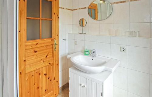 een badkamer met een wastafel en een houten deur bij Awesome Apartment In Zislow With Kitchen in Zislow