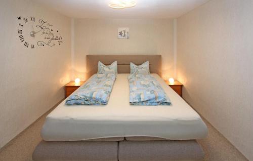 um quarto com uma cama com duas almofadas e um relógio em 2 Bedroom Cozy Home In Blankensee Ot Gro Sch em Blankensee