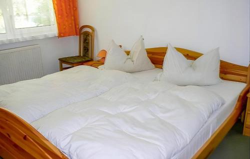 a large white bed with white pillows on it at Beautiful Apartment In Ostseebad Breege Ot Ju With Kitchen in Drewoldke