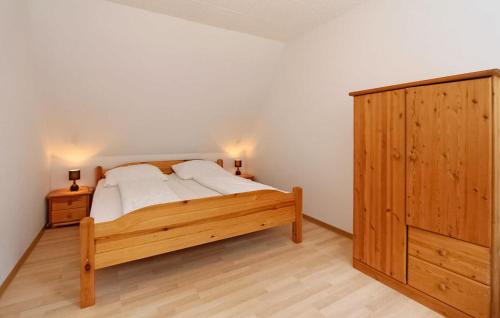 - une chambre avec un lit en bois et une armoire en bois dans l'établissement Pet Friendly Apartment In Blankensee With Kitchen, à Blankensee