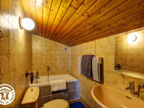a bathroom with a tub and a toilet and a sink at Villa d'architecte 200m² avec piscine privée et cheminée - FR-1-496-35 in Pommiers-en-Forez