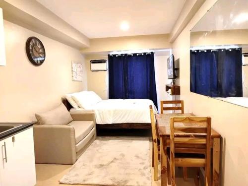 een kleine kamer met een bed en een bank bij Atria T3 Unit 624 Pool View in Iloilo City