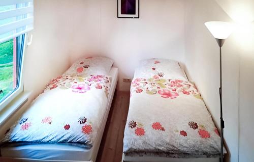 two beds in a room with a lamp at Lovely Home In Boitzenburger Land Ot With Kitchen in Rosenow