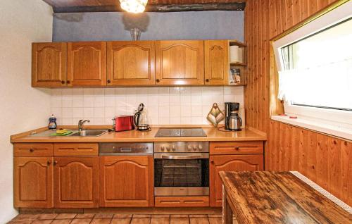 Una cocina con gabinetes de madera y un fregadero. en Ferienhaus Fürstenhagen, en Fürstenhagen