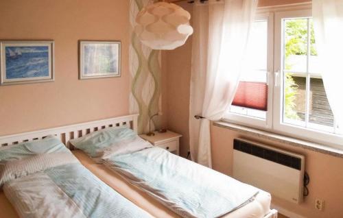 Schlafzimmer mit einem Bett und einem Fenster in der Unterkunft Beautiful Home In Mnkebude With Kitchen in Mönkebude