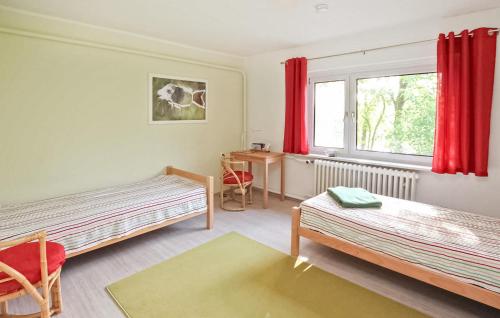 1 dormitorio con 2 camas, escritorio y ventana en Awesome Apartment In Nardevitz Auf Rgen With Lake View en Vietzke