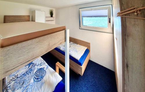 a small room with two bunk beds and a window at 3 Bedroom Lovely Ship In Waren mritz in Waren