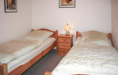 two twin beds in a room with a night stand and a lamp at Stunning Home In Klpinsee-usedom With Kitchen in Kolpinsee
