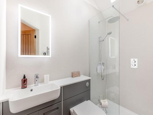 a white bathroom with a sink and a shower at The Loft-uk45061 in Tideswell