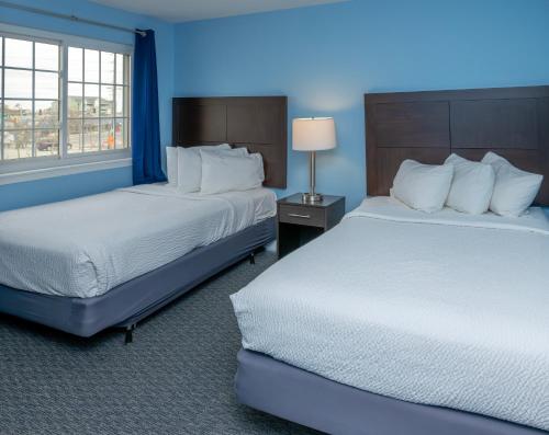 a blue room with two beds and a window at Commander Beach House Hotel in Ocean City