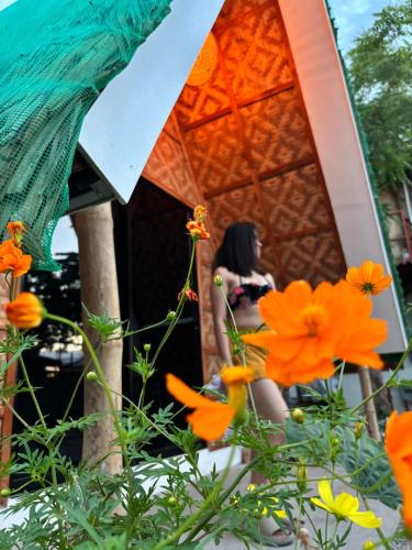 a woman sitting in a tent with orange flowers at Villa Lovi Panagsama Beach Moalboal in Moalboal