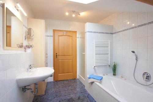 a bathroom with a white tub and a sink and a tubermott at Landhaus Koch in Höslwang