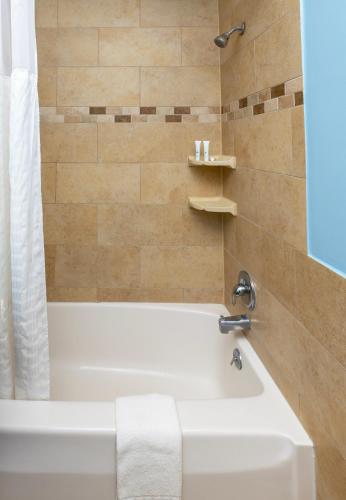 a bathroom with a white tub and a shower at Commander Beach House Hotel in Ocean City
