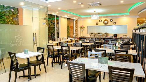 a restaurant with white tables and chairs and a counter at Solo Grand City in Lawean