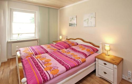 ein Schlafzimmer mit einem großen Bett mit rosa Bettwäsche und einem Fenster in der Unterkunft 2 Bedroom Nice Apartment In Grabowhfe Ot Sophienh 