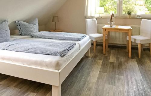 a bedroom with two beds and a table and chairs at Pet Friendly Apartment In Ueckermnde seebad With Kitchen in Neuendorf