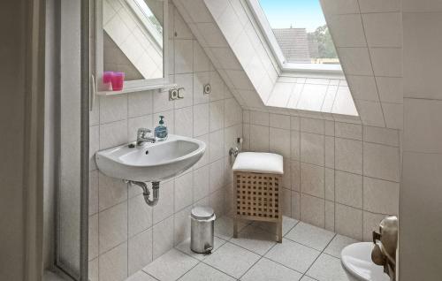 a bathroom with a sink and a toilet with a window at Pet Friendly Apartment In Ueckermnde seebad With Kitchen in Neuendorf
