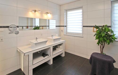 a white bathroom with two sinks and a mirror at Nice Home In Grnow Ot Ollendorf With Kitchen in Blankensee