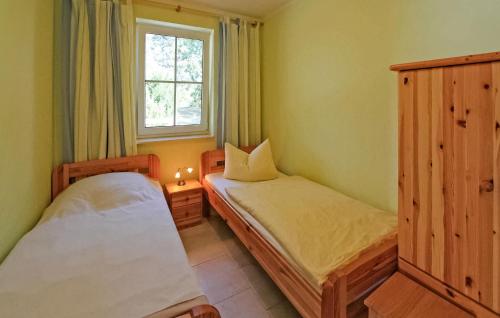 um pequeno quarto com 2 camas e uma janela em Awesome Home In Karlshagen ostseebad With Wifi em Ostseebad Karlshagen
