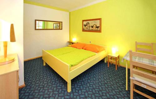 a bedroom with a yellow bed in a room at 1 Bedroom Awesome Home In Rheinsberg Ot Zechline in Scharfenberg