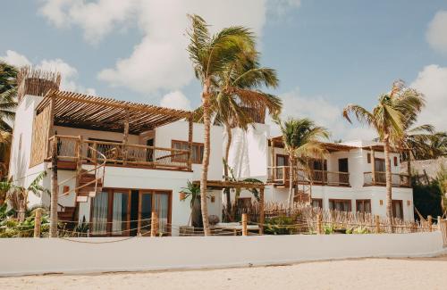 ein Haus am Strand mit Palmen in der Unterkunft Villa Mango Beach Houses in Praia de Moitas