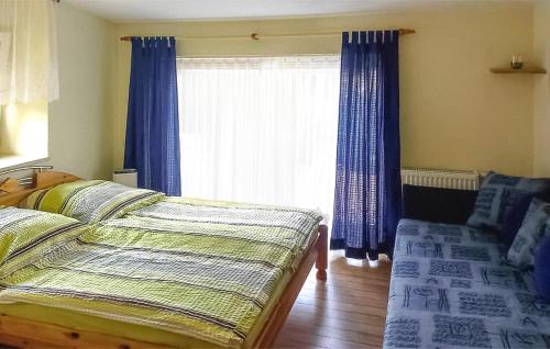 um quarto com 2 camas e uma janela com cortinas azuis em 1 Bedroom Nice Apartment In Waren mritz em Waren
