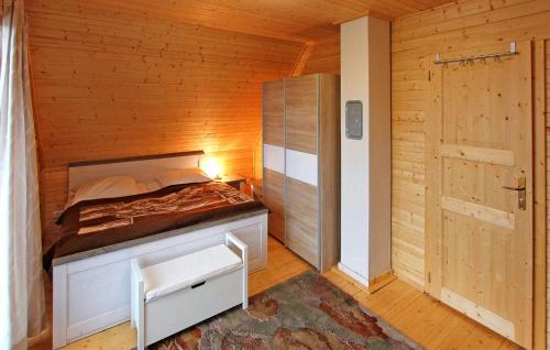 3 Bedroom Lovely Home In Tollenseheim في Krickow: غرفة نوم بسرير في غرفة خشبية