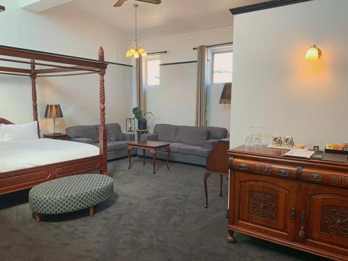 ein Schlafzimmer mit einem Bett und ein Wohnzimmer in der Unterkunft The Macquarie Hobart in Hobart