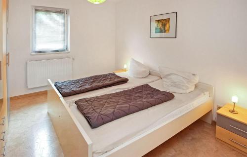 a bedroom with a large white bed with brown sheets at Lovely Apartment In Walow Ot Strietfeld With Lake View in Strietfeld