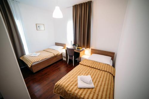 Cette chambre comprend 2 lits et une table. dans l'établissement Hotel Wojtyla, à Međugorje