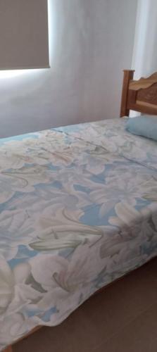 Una cama con colcha floral encima. en Casa en Chiriquí, Las Lomas, 